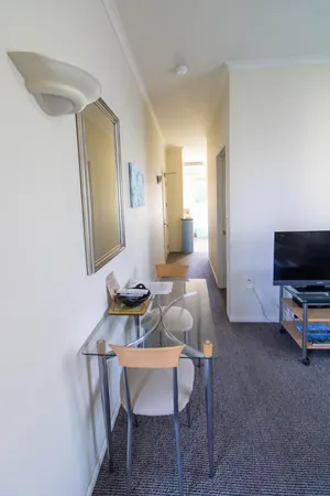One Bedroom Unit Desk and Hallway Glass desk and hallway leading through to the bedroom and kitchenette in the one bedroom unit