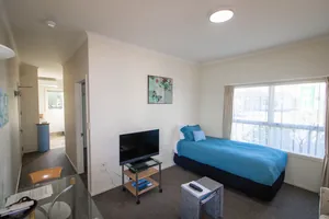One Bedroom Unit Living Area One bedroom unit living area with single bed, TV and large window overlooking the street