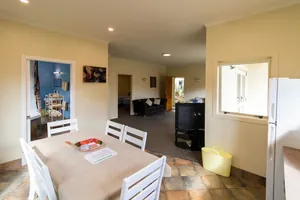 Two Bedroom Unit Dining and Lounge Dining table looking through to the lounge, bathroom and bedrooms in the two bedroom unit