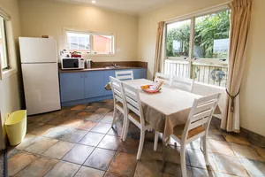 Two Bedroom Unit Kitchen Dining Full kitchen and dining area with table for six, fridge and garden outlook in the two bedroom unit