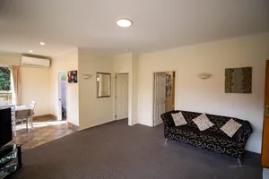 Two Bedroom Unit Lounge Sofa Lounge with patterned sofa and doorways to the bathroom and dining area in the two bedroom unit