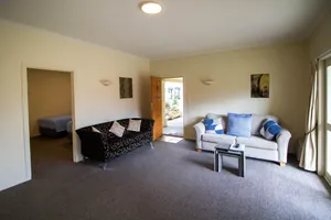 Two Bedroom Unit Lounge Two bedroom unit lounge with two sofas, artwork and the front door open to a sunny courtyard