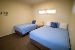 Two Bedroom Unit Second Bedroom Second bedroom with a double bed and single bed in blue linen in the two bedroom unit