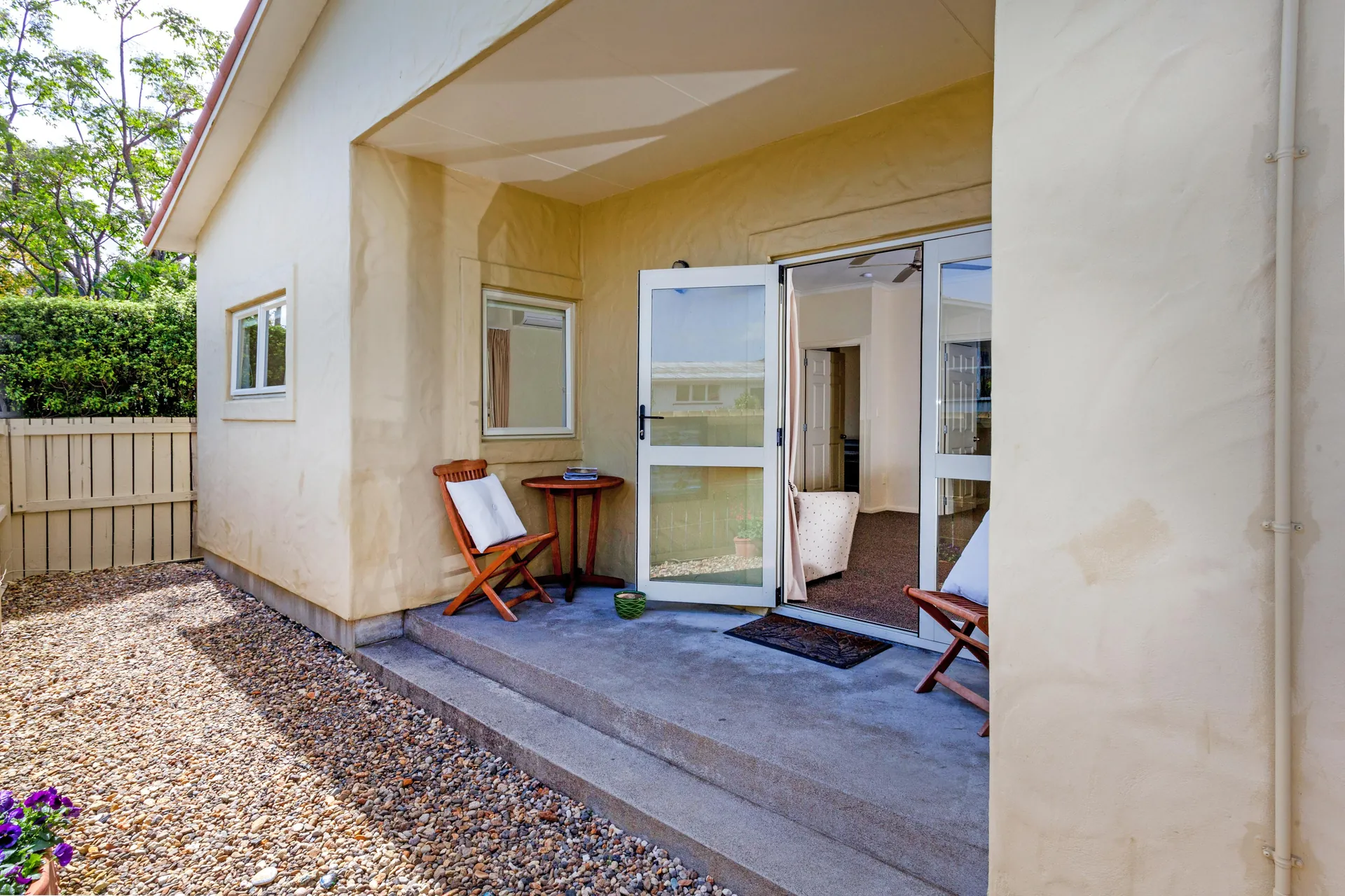 Two Bedroom Unit Entrance Private entrance porch of the two bedroom unit with outdoor chairs and open glass door