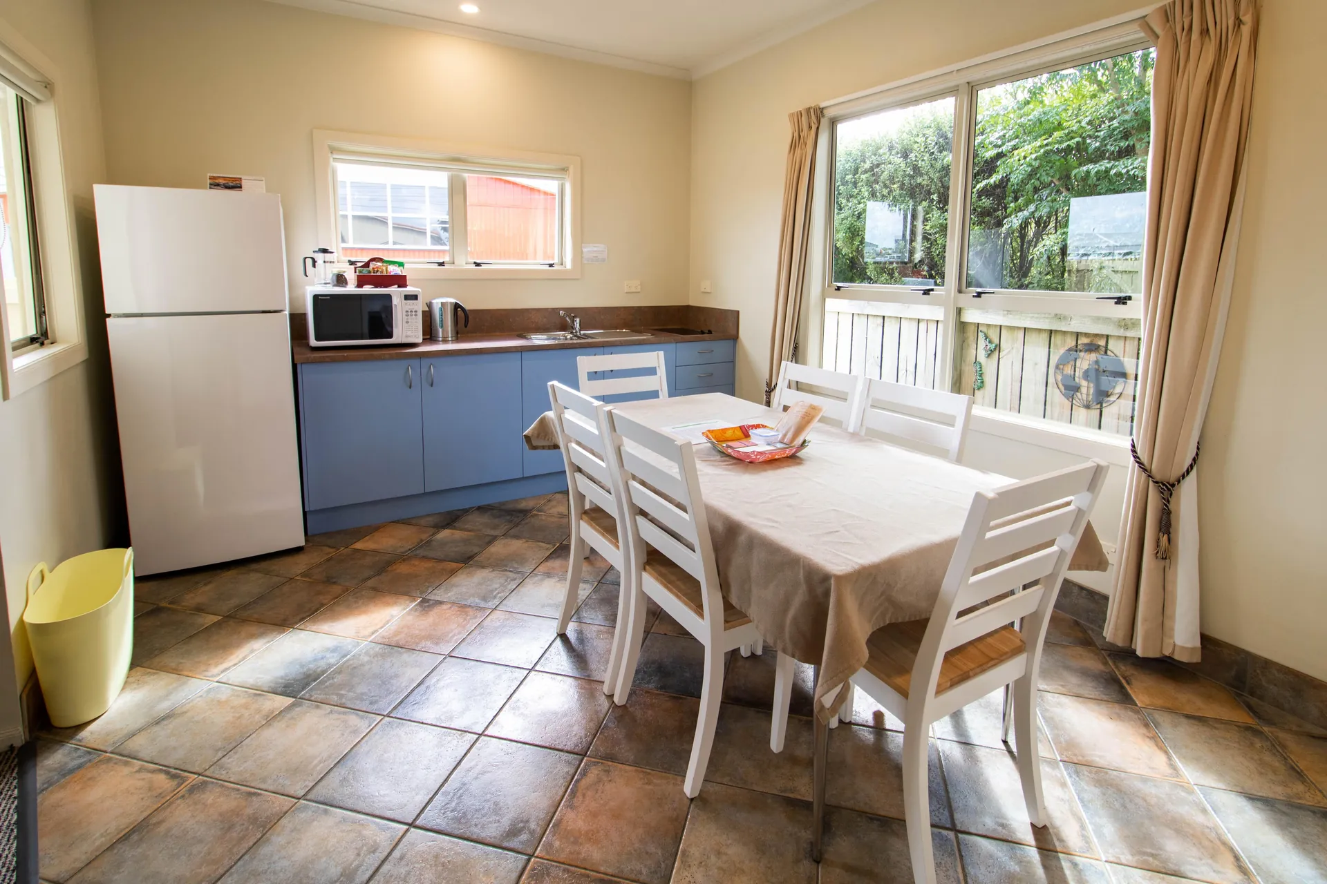 Two Bedroom Unit Kitchen Dining Full kitchen and dining area with table for six, fridge and garden outlook in the two bedroom unit
