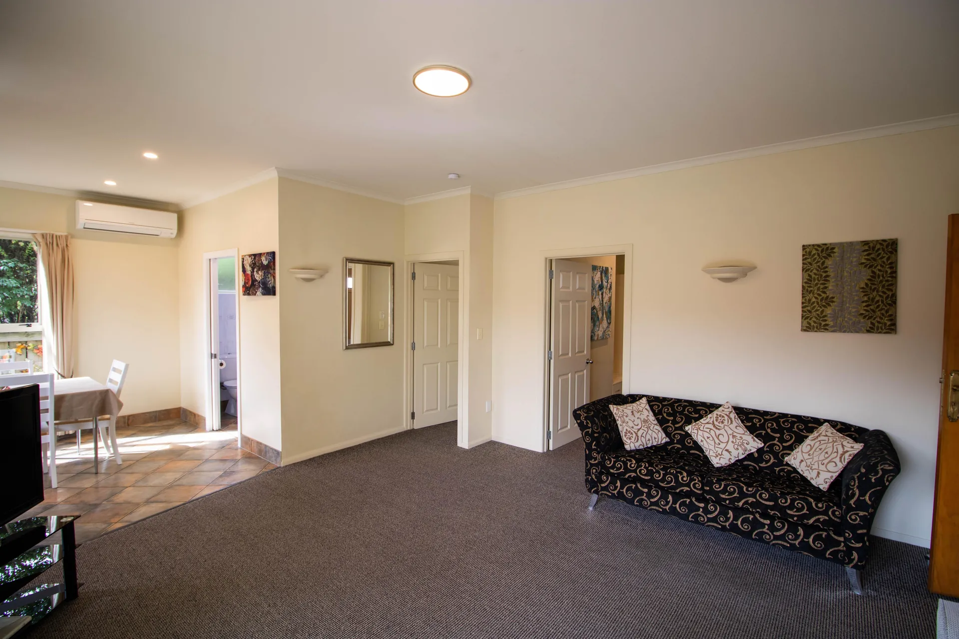 Two Bedroom Unit Lounge Sofa Lounge with patterned sofa and doorways to the bathroom and dining area in the two bedroom unit