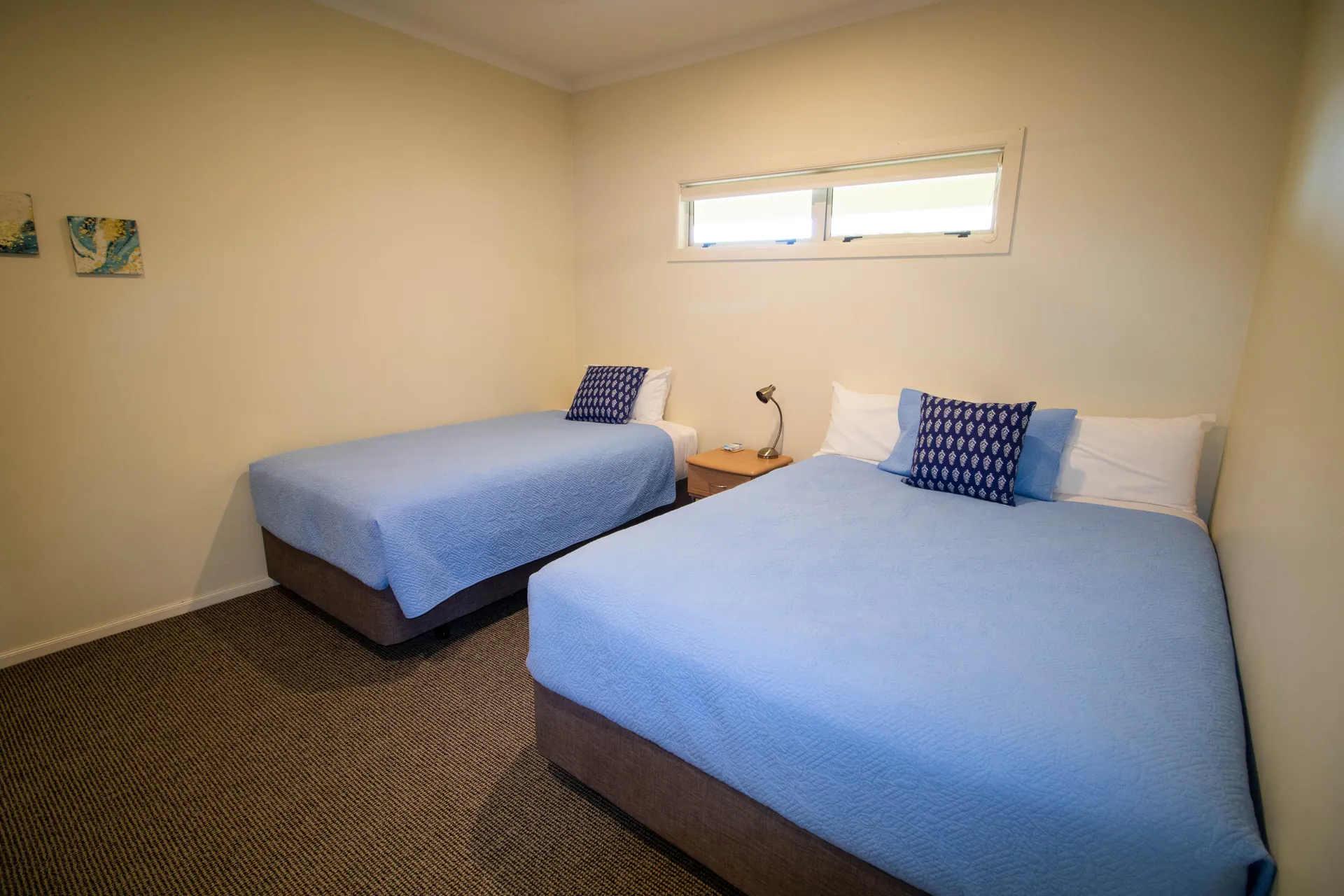 Two Bedroom Unit Second Bedroom Second bedroom with a double bed and single bed in blue linen in the two bedroom unit