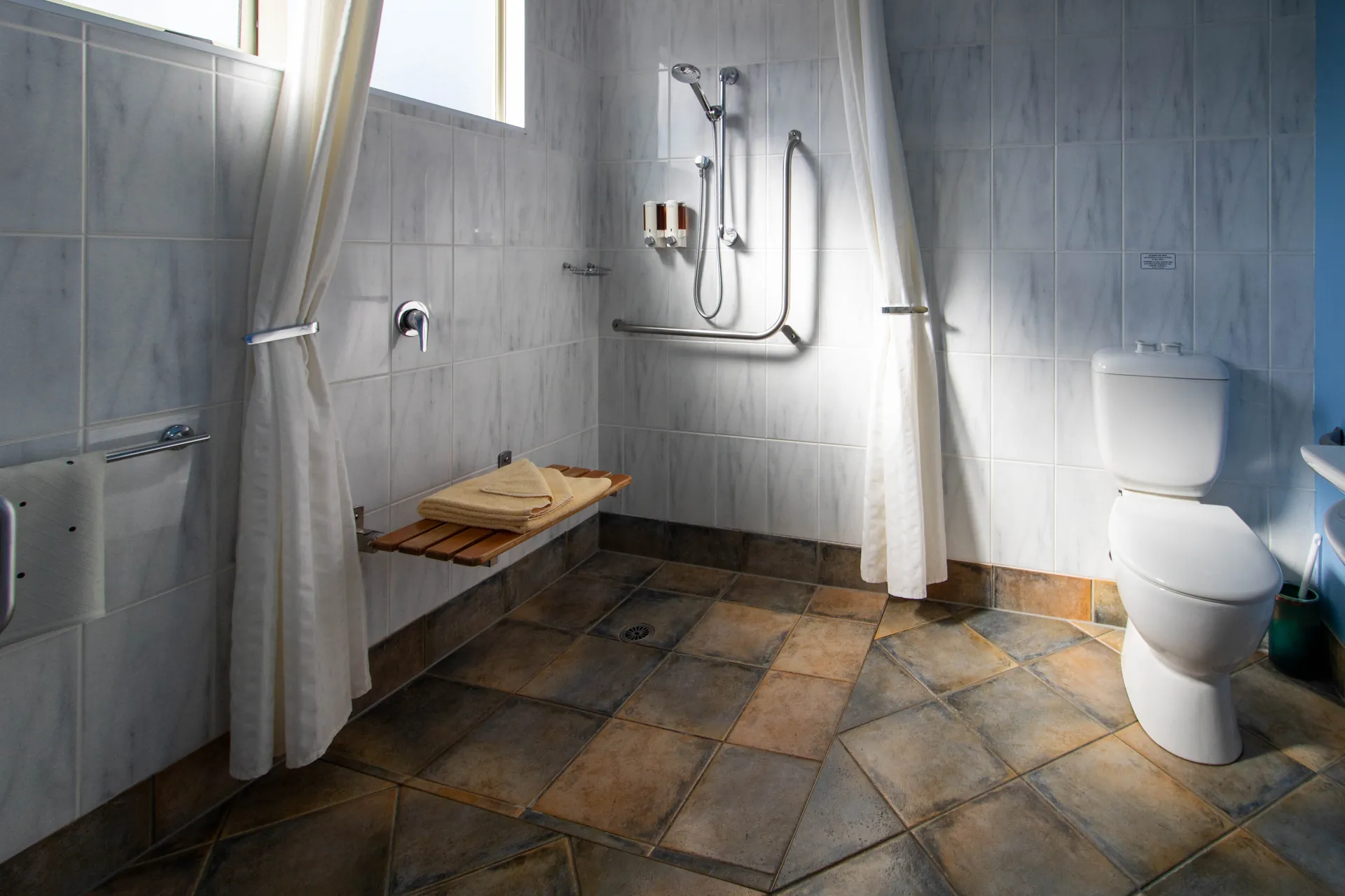 Access Studio Accessible Shower Wheelchair accessible wet room shower with grab rails, fold down bench seat and toilet