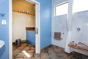 Access Studio Bathroom and Kitchenette Accessible bathroom with walk in shower and towel bench looking through to the kitchenette
