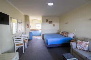 Access Studio Bed and Kitchenette Access Studio king bed and sofa with the kitchenette and dining area beyond