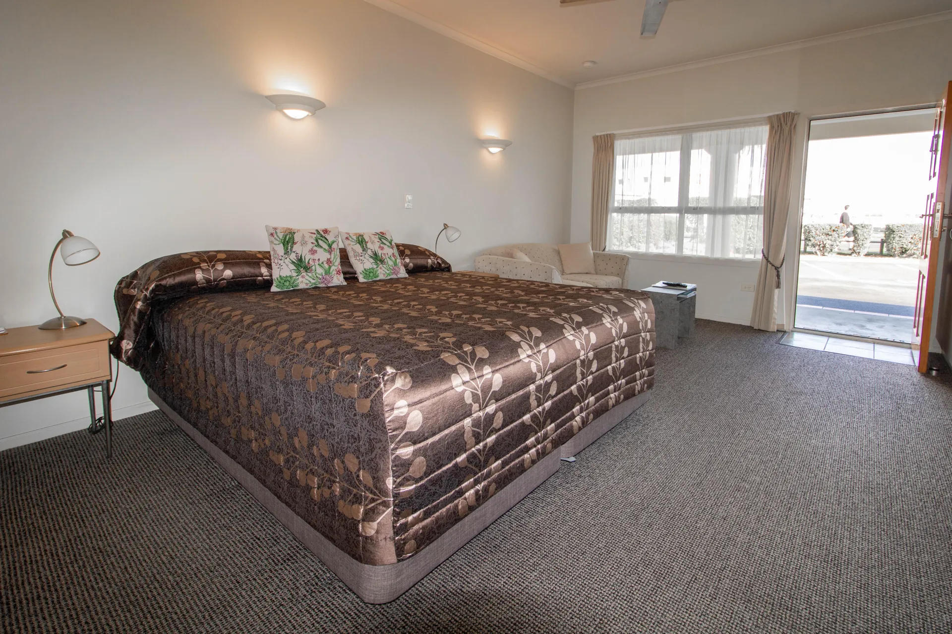 Studio King Bed Studio with king bed in patterned bedspread and door open to the sunny courtyard