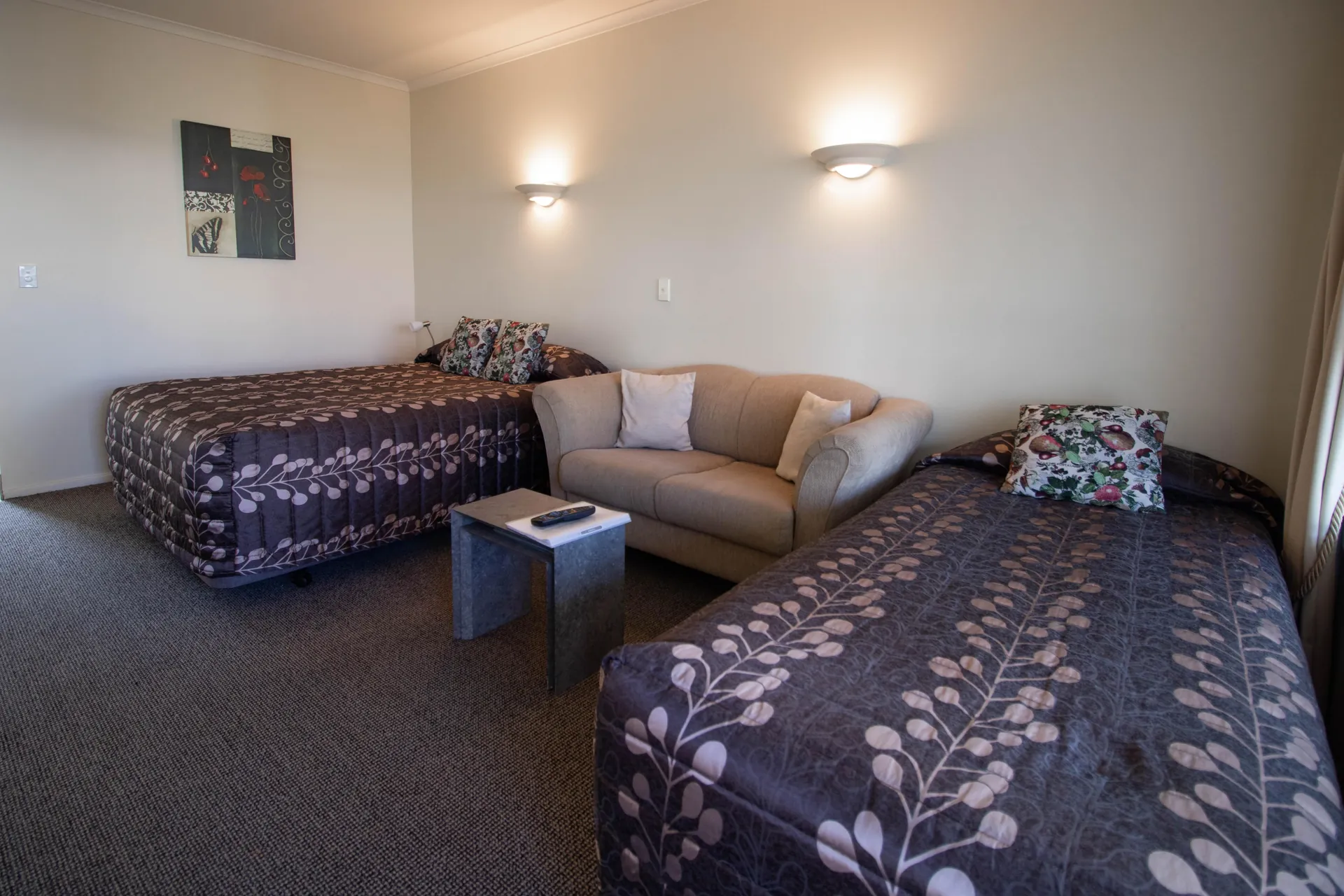 Studio Twin Beds Two beds in patterned bedspreads with a sofa between in the Twin Studio