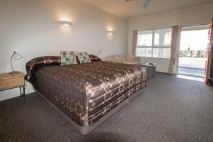 Studio King Bed Studio with king bed in patterned bedspread and door open to the sunny courtyard
