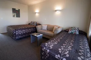 Studio Twin Beds Two beds in patterned bedspreads with a sofa between in the Twin Studio
